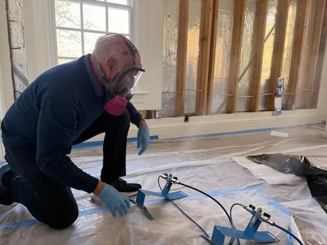 A restoration technician setting drying equipment in an Pittsburgh home stripped to the studs